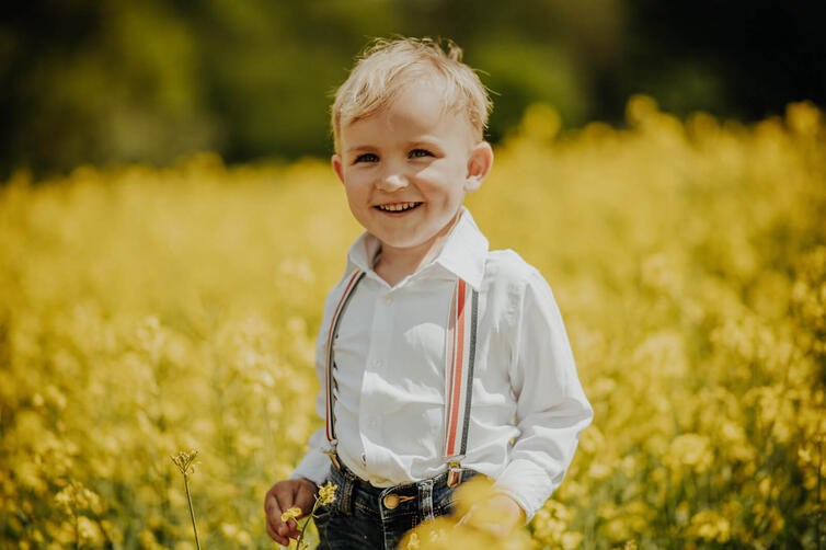 dziecko stoi wśród rzepaku